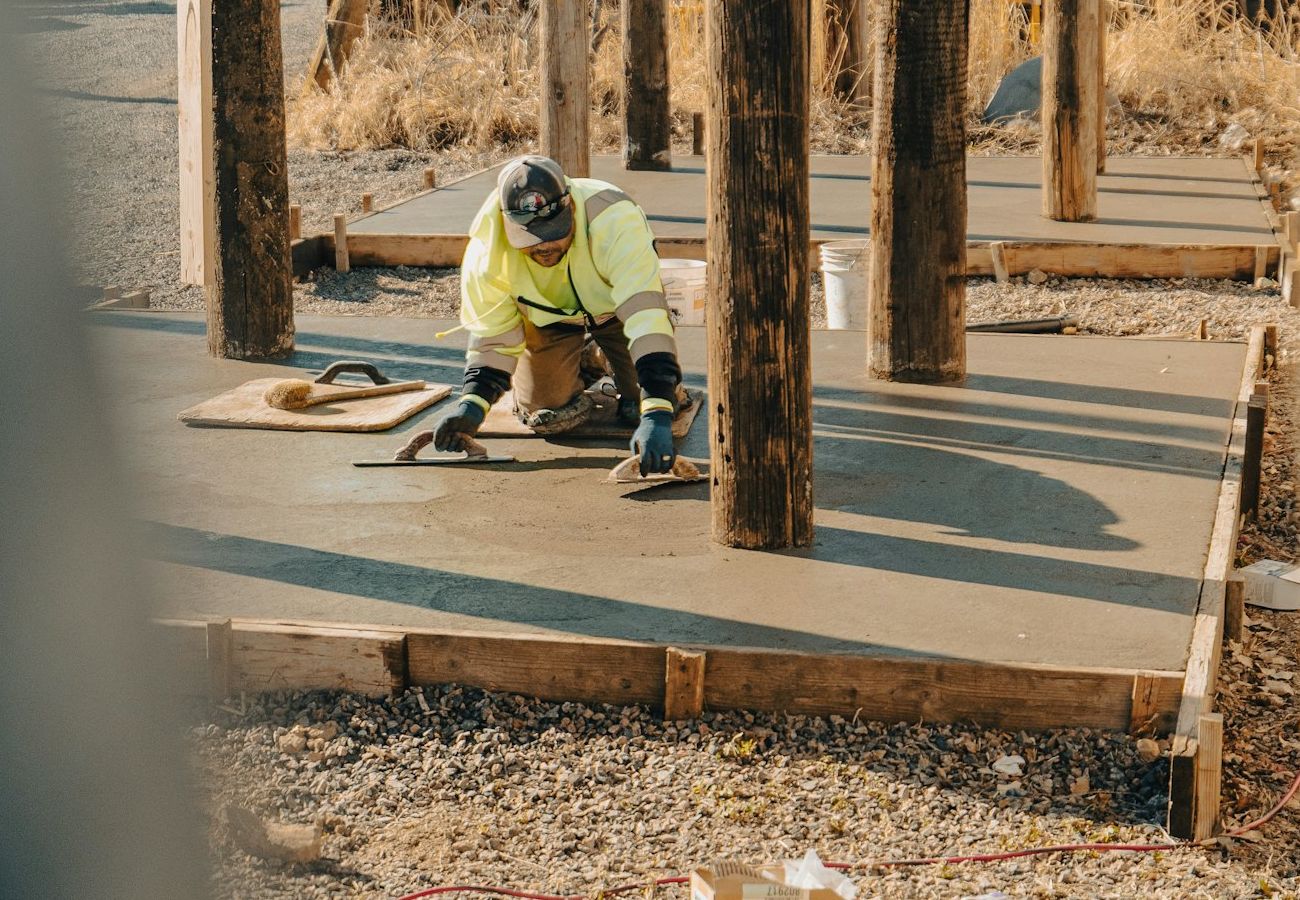 Worker hand-finishing a fresh concrete pour